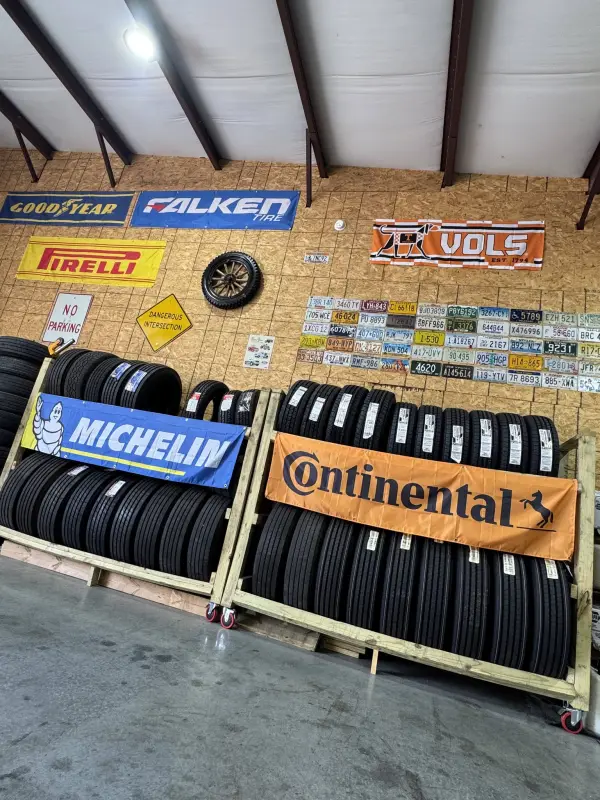 The tire wall in the Blessed Beginnings bay: new tires racked under brand banners